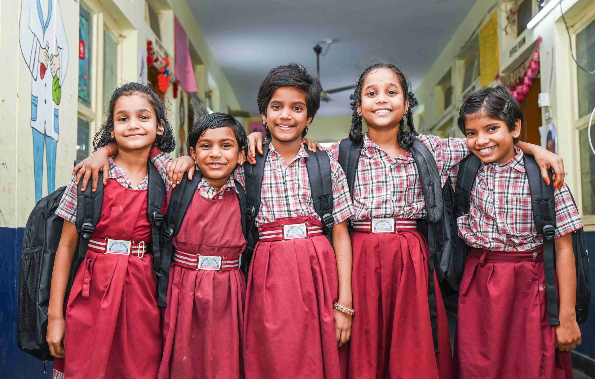 Schoolgirls in India smiling with new backpacks