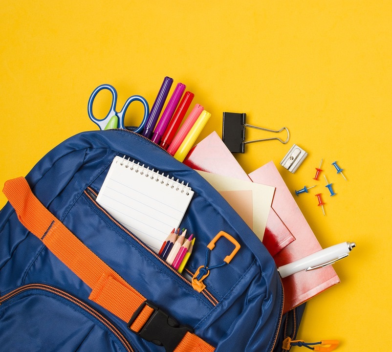 A backpack filled with notebooks, pencils and school supplies
